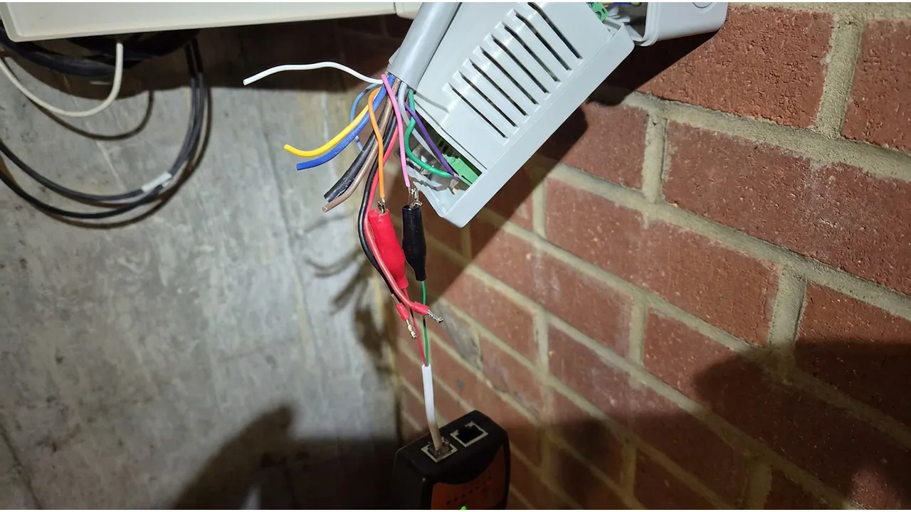 Test leads clipped to visible control wiring during an electrical fault-finding check.