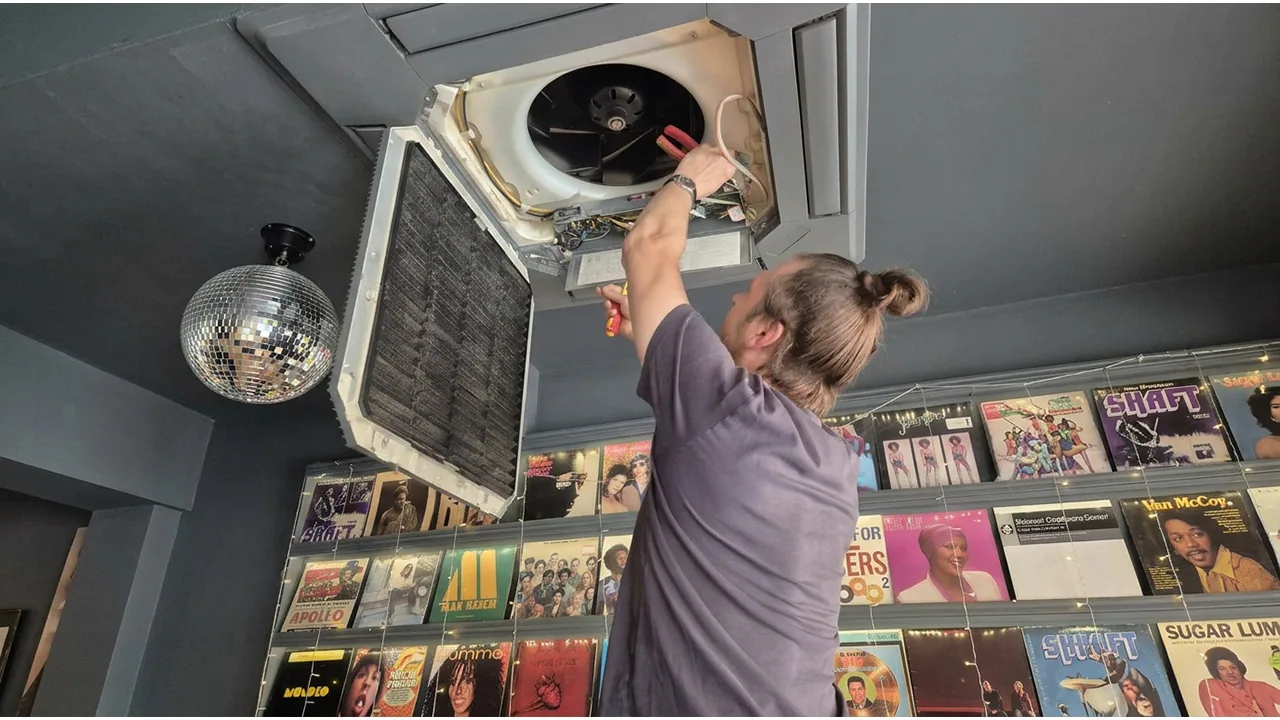 Open ceiling-mounted ventilation unit with its internal fan and wiring visible.