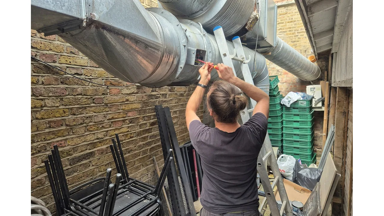 Ventilation duct control wiring beside an access ladder.