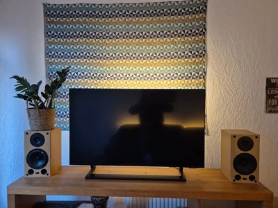 TV and speaker setup with concealed lighting behind the screen.