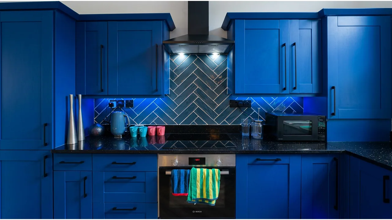 Blue kitchen with LED lighting beneath the wall cabinets and cooker hood