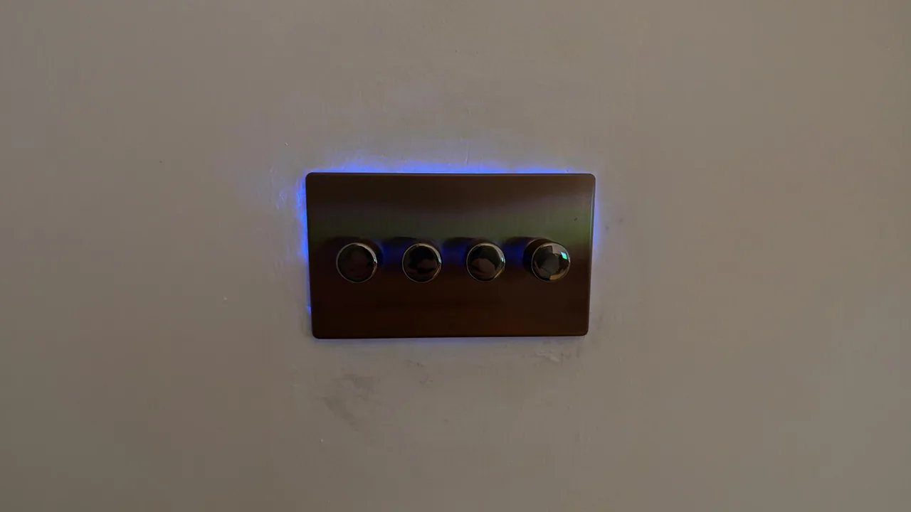 Backlit four-button wall control used for evening lighting scenes.