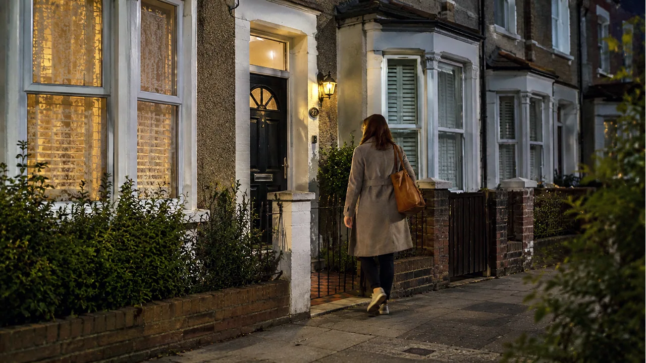 Evening front path and doorway lighting on a terraced home.